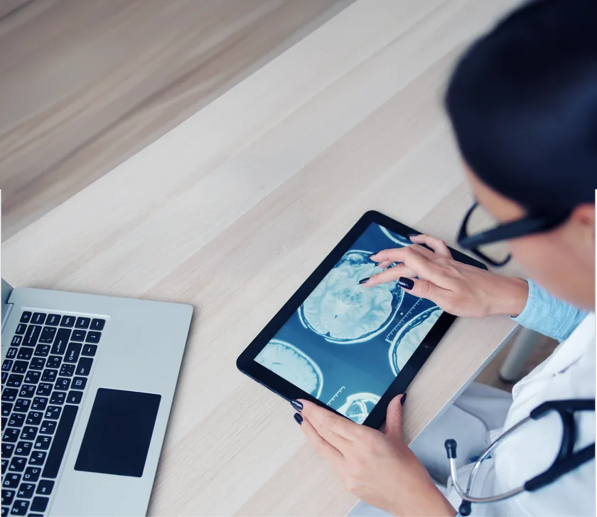Médica analisando exames de imagem em um tablet